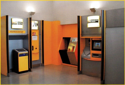 Bild vom Firmenprospekt von Crisplant - Ausschnitt des Schowrooms der Deutschen Post AG im Tulpenfeld in der Nähe der Zentrale der DPAG in Bonn - im rechten Teil mit dem Paketannahmeautomat von Crisplant (in der Ecke hinten) sowie rechts der damals neue Sielaff Münzwertzeichendrucker mit einer daneben befindlichen Portoermittlungshilfe (PED) hier in der Ausführung manuelle Schablone